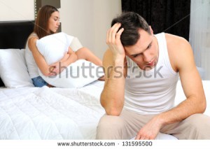 stock-photo-upset-man-having-problem-sitting-on-the-bed-with-his-girlfriend-131595500